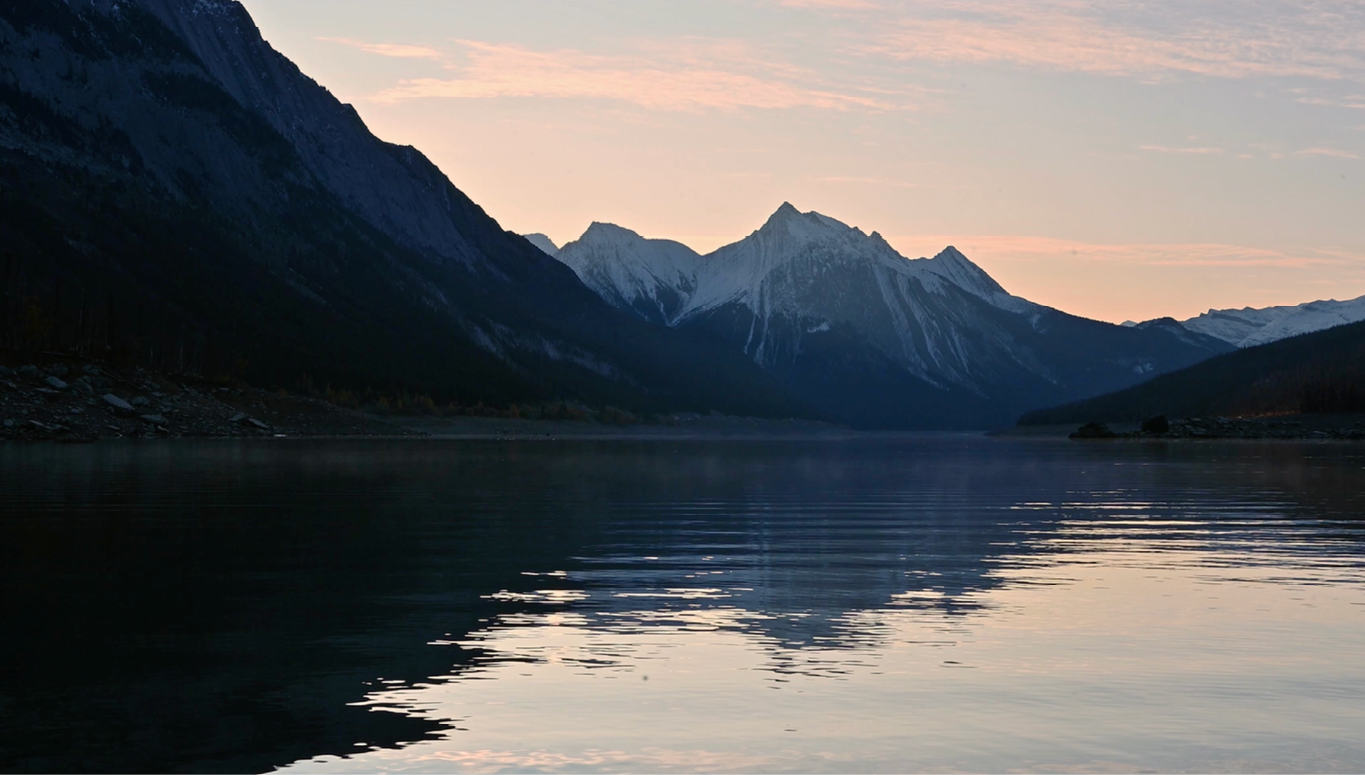 A lake reflects the sunset and mountains in the background.

AI generated content